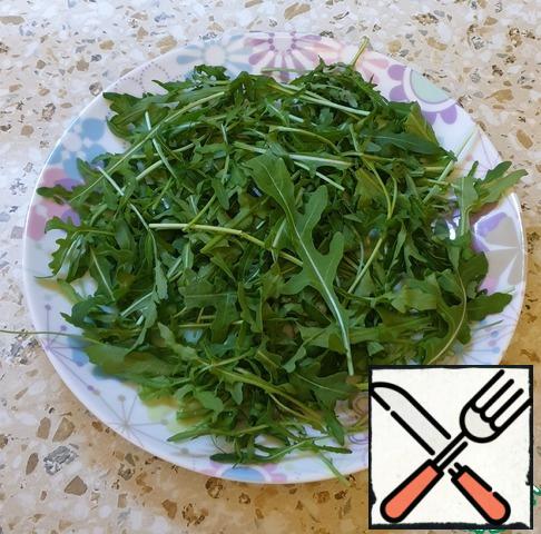 Boil the eggs for 4 minutes in boiling water, peel them from the shell.
Put the washed arugula on a plate.