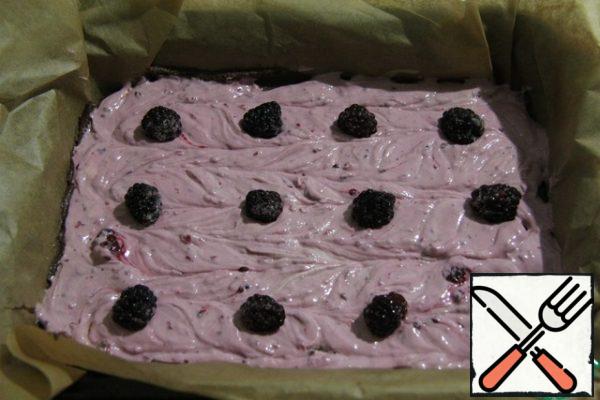 Lay whole blackberries so that after baking they become the center of the cakes.