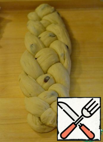 Throw the third tourniquet over the second. Right to left.
Finish it. Connect the ends together and tuck under the braid.
Spread the baking sheet with baking paper. Put the braid on paper.