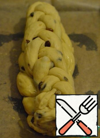 Put the second (of three bundles) braid on top.
Lightly press the dough along the braid with the edge of your hand.
Coat with the egg.