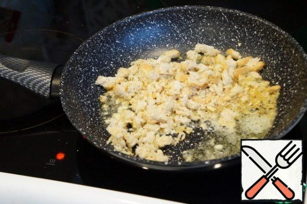 In a preheated frying pan, melt the butter (you can drop a little vegetable oil so that it does not burn), lightly fry the chopped garlic. Send to it the bread crumbs, mix well. Cook for a couple of minutes over low heat.