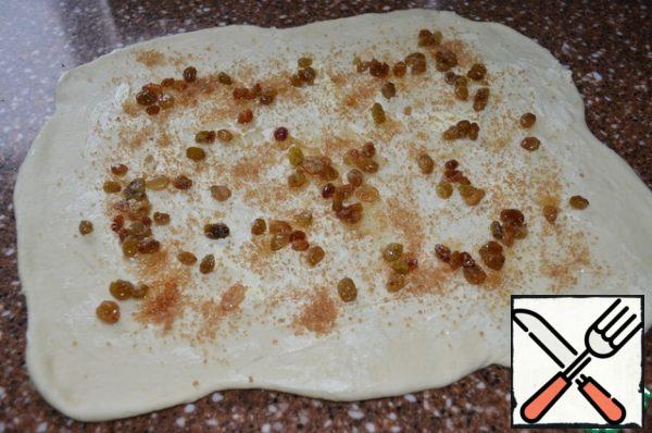 Roll out the dough into a layer, 35 / 22 cm..
Brush with soft butter and sprinkle with brown sugar.
Scatter the "cognac" raisins. Roll it up.