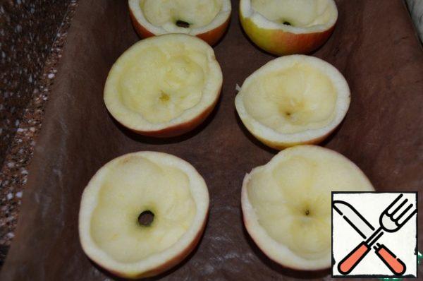 Cut the apples in half, remove the pulp, making cups.
Place on a baking sheet.
