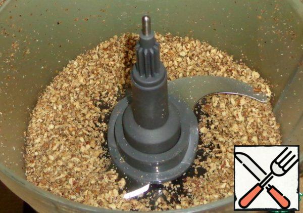 Insert a chopper knife into the bowl. Chop the dried walnuts using a food processor.