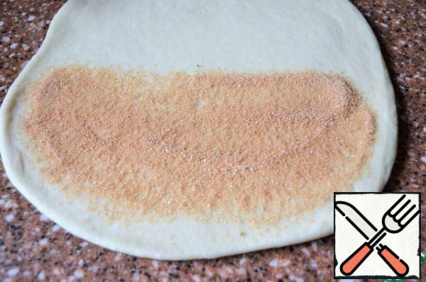 Knead the fermented dough and divide it into two parts.
Roll each into a circle with a diameter of 24-25 cm.
Spread the spicy mixture over half a circle, 1 tbsp.