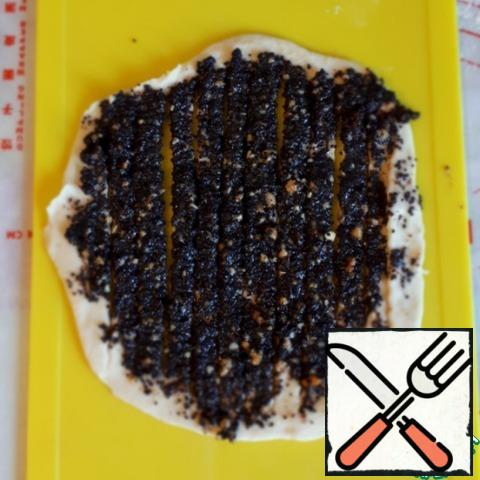 Roll out a thin cake and spread it with poppy seed filling. Cut the tortilla into strips 0.5 cm wide, but leaving the edges uncut about 0.5-0.7 cm. it is Convenient to use a pizza knife.