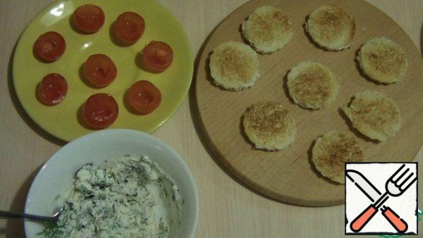 Cut out the mugs from the loaf using a mold or a glass. Dry in a dry frying pan until browned. Add finely chopped dill and basil, season with salt and pepper to taste and mix. Cherry tomatoes need to cut off the bottom and peel the pulp. Stuff the tomatoes with the prepared cheese.
