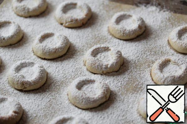 Hot cookies with a strainer sprinkle with powdered sugar.