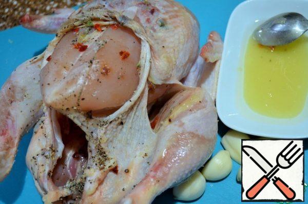 Mix honey and vegetable oil, peel the garlic.
Coat the chicken inside and out with this mixture, put garlic cloves in the chicken. Place in a preheated oven.