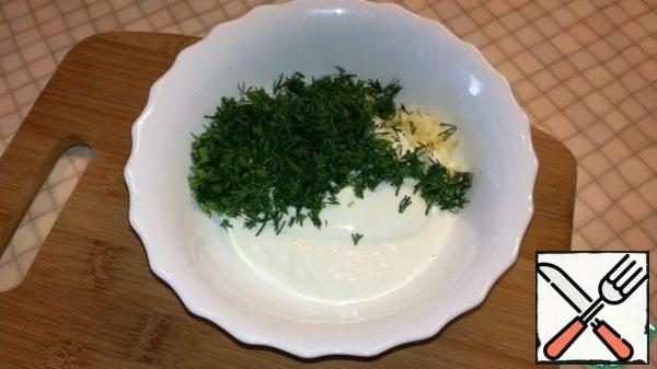In a bowl, mix sour cream, finely chopped garlic and dill.