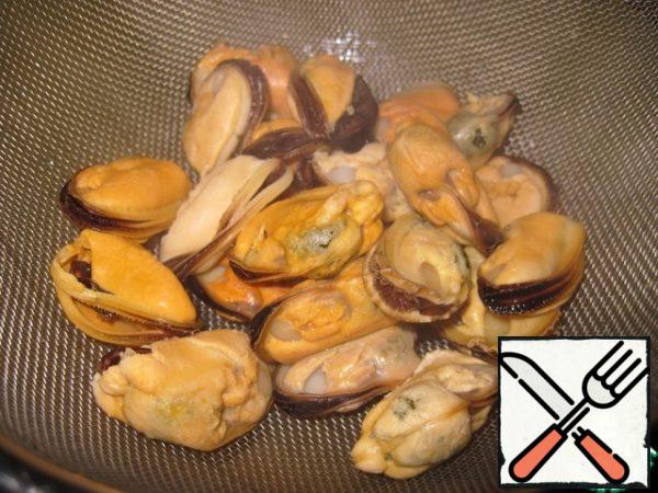 Wash mussels (without defrosting) with running water. In a saucepan, boil water, add a little salt, toss the mussels and cook for 5-7 minutes. Then drain in a colander.