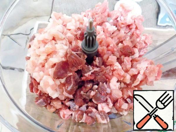 Chop the pork, brisket and lamb finely and put it in the bowl of a food processor.
