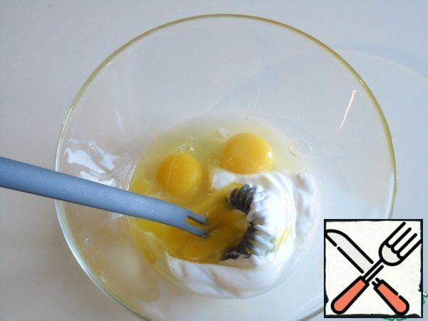 In a bowl, carefully mix the sour cream with the eggs.