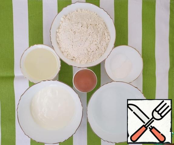 Prepare all the ingredients for the dough: flour, egg, natural yogurt without additives, olive oil, baking powder, water with salt dissolved in it.