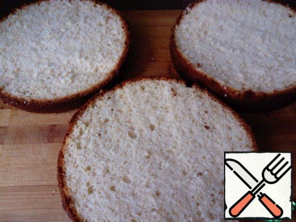 After the biscuit is baked, put it on the Board and allow to cool completely. Then cut the cooled biscuit into three cakes. If you like a wetter sponge cake, then you can soak the cakes.