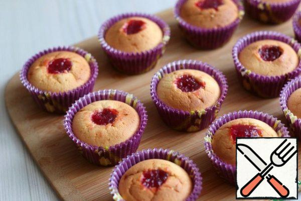 Remove the middle of the cooled cupcakes with a knife. Fill the middle with cherry jam or other jam of your choice.