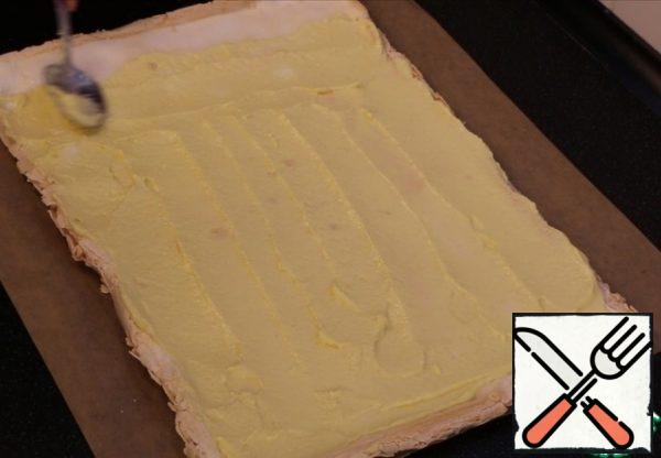 And only when the roll is completely cool, evenly distribute the cream. Not missed the mark leaving the free edge a couple of inches on one side. So that when we rolled the roll, the cream didn't leak out.
