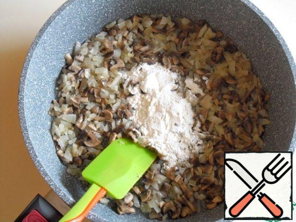 Usually julienne is baked in a sauce. In order not to do it separately, I simplified this step and added flour to the mixture of onions and mushrooms.
Add a little more butter and in the center of the pan fry flour for a minute, or until the characteristic pleasant smell of fried flour.