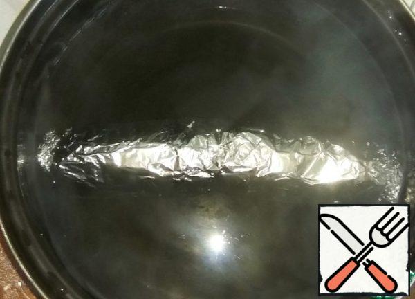 In boiling water, lower the roll in foil. Cook for 30 minutes over moderate heat.