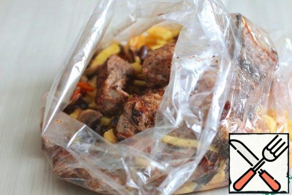 Put the potato strips, fried vegetables and mushrooms in the baking sleeve, and put the prepared and fried pork ribs until Golden brown.