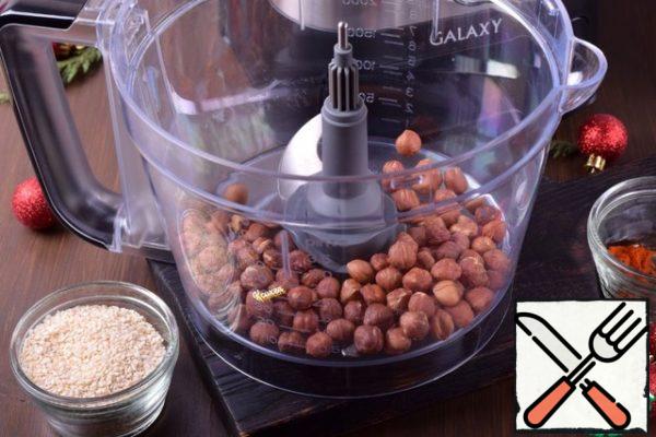 While the cabbage is baked, prepare a nut sprinkle.
Chop the hazelnuts into crumbs. I'll do it with a food processor. Thanks to the pulse mode (the "P" button), I got a nut crumb, not flour.