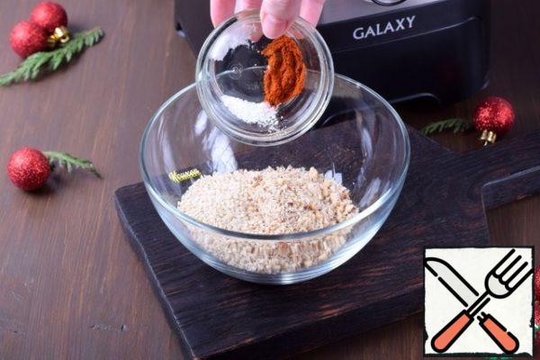 Pour the nut crumbs into a deep bowl, add sesame seeds, paprika and salt. Mix everything together.