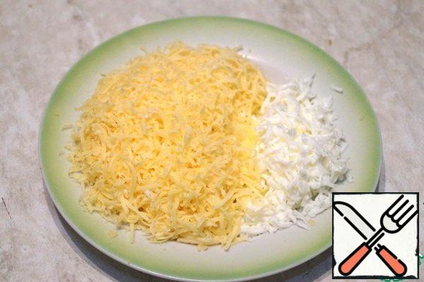 Boil the eggs and peel them from the shell. Grate the hard cheese and egg white on a fine grater.