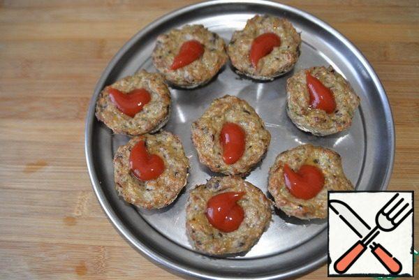 We get a ready-made meat base. Put half a tablespoon of tomato ketchup in the middle of each billet.