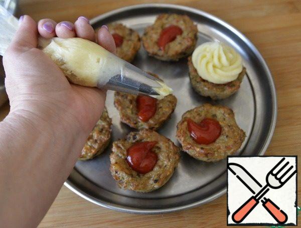 Mashed potatoes are put in a cooking bag with a convenient nozzle, I have an "open star". Put the puree on top of the ketchup. If there is no nozzle, you can simply cut off the end of the package and plant it with a neat slide.