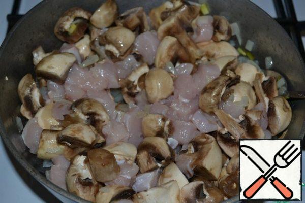 Chicken breast fillet cut into small cubes, mushrooms - into 4 parts. If the mushrooms are large, then cut into 8 parts.
Put the sliced chicken and mushrooms in the pan with the onion, add salt and pepper and fry over medium heat until the resulting liquid appears. Add a high heat and fry, stirring constantly, until the moisture evaporates.