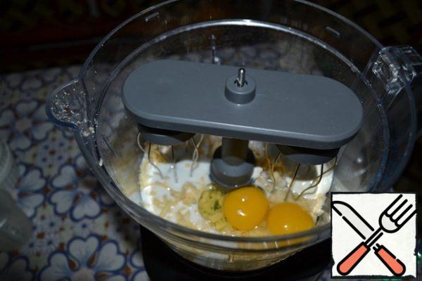 Without putting the cheese out of the bowl of the combine, remove the lid and change the grater attachment to the whisk attachment for whipping. Prepare the mixture for pouring: put eggs, sour cream, milk, a little salt and a pinch of black pepper in the bowl of the combine. Beat until smooth.