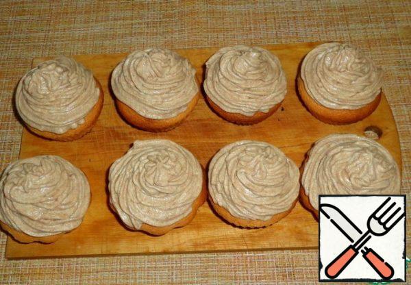 Decorate the cupcakes with cream using a cooking syringe. Sprinkle with pastry decorations. Put the dessert in the refrigerator for 2 hours.