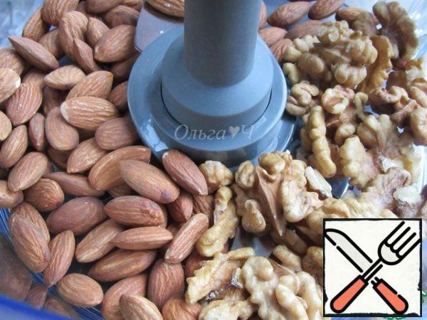 Prepare the base for the cake. Put the almonds and walnuts in the bowl of a food processor with a "Chopping Knife" attachment.