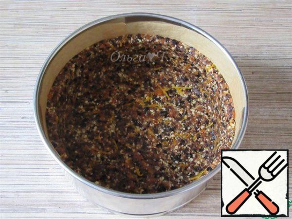 Form for a cake (I have a diameter of 16.5 cm), cover with baking paper, put the nut mass with dried fruits, distribute along the bottom, make the sides. Remove to the freezer for 20-30 minutes.