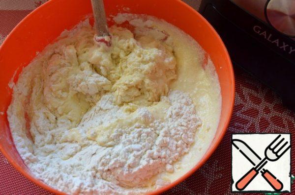 Mix the flour and baking powder.
Transfer the curd-oil mixture to a bowl with the dry products.
Gently mix until smooth.
