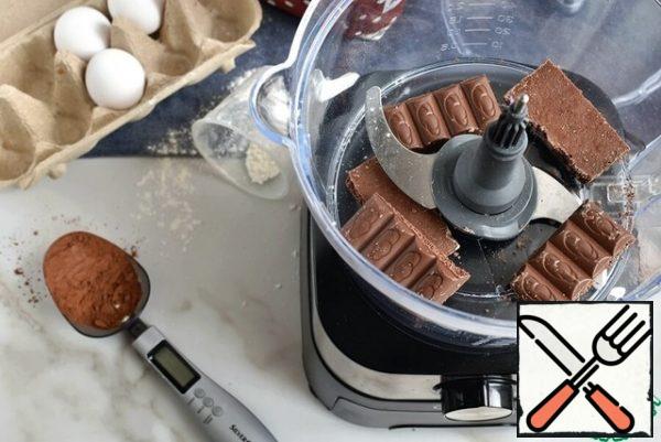 Set the oven to warm up at a temperature of 180 degrees. Place a knife in the bowl of the combine and put the broken pieces of chocolate. I recommend dark, but it's a matter of taste.
In pulse mode, chop the chocolate into fairly large pieces.
