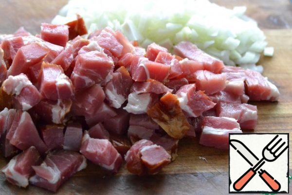 Finely chop the onion.
Cut the smoked meat into medium pieces. Fry in sunflower oil. The fire is active.
It is advisable to cook cabbage in a saucepan with a thick bottom.