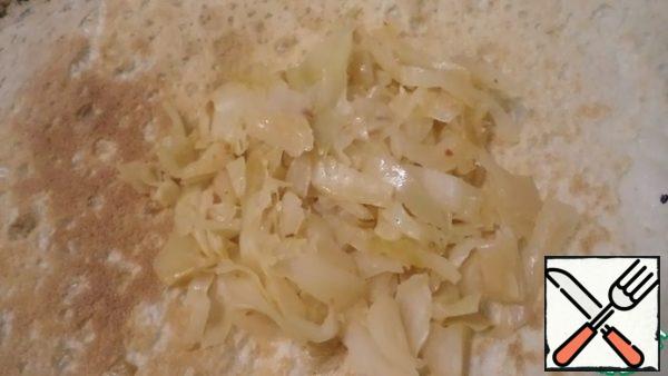 Cut fresh cabbage and cook with a little water and oil under the lid until soft. Cool slightly and put on the cheese.