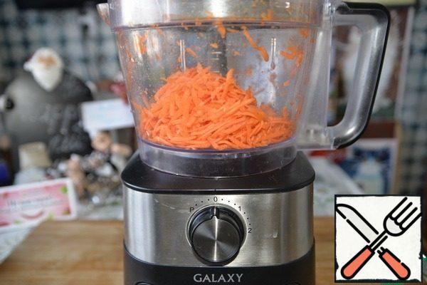 First, prepare the spicy carrots.
Grate the carrots in strips. For this purpose it is convenient to use the shredder of a food processor.