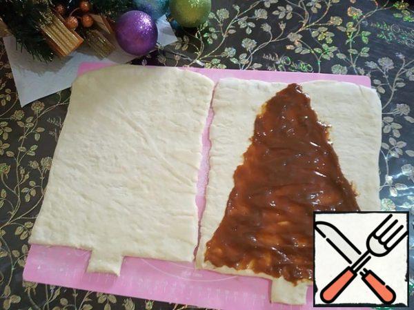 On one layer of dough, spread boiled condensed milk in the form of a triangle.