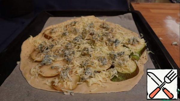 Starting to shape our pizza. First, spread the pear, then sprinkle with mozzarella and Gorgonzola. Sprinkle with spices to your taste. And put in the oven for 20 minutes.