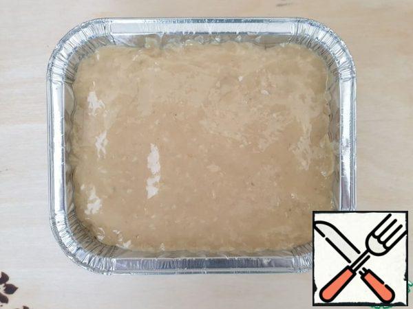 To cool the burfi, it is better to use a disposable form, having previously greased it with vegetable oil.
Put the dessert in the form and level.
