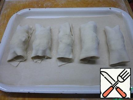 Roll out the puff pastry, divide it into the desired number of rectangles and wrap the slightly cooled rolls in them. Spread on a sheet lined with baking paper. Continue to bake at the same temperature until Golden brown.