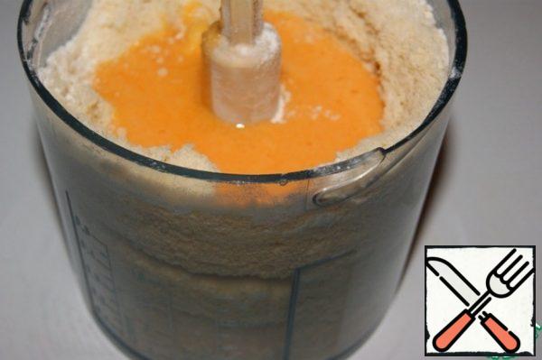 Add the zest, pour the yolk mass over the butter crumbs and whisk everything again with a blender.