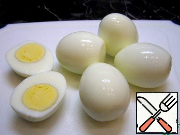 Cut hard-boiled eggs in half and remove the yolks.