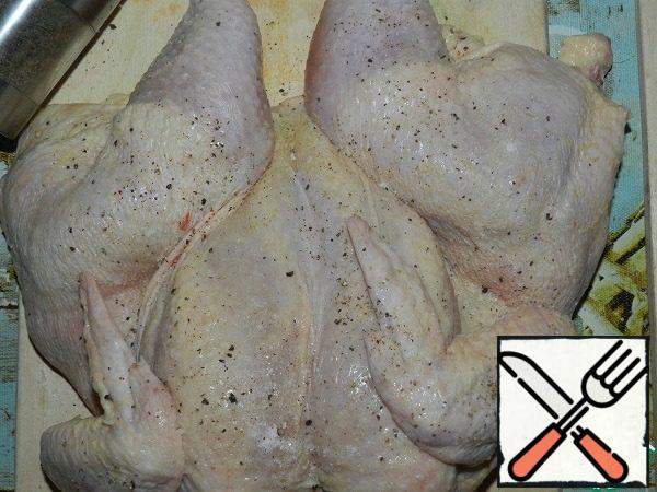 Open the chicken so that the breast is in the middle. Rub it with salt (0.5 tsp) and crushed black pepper on both sides.