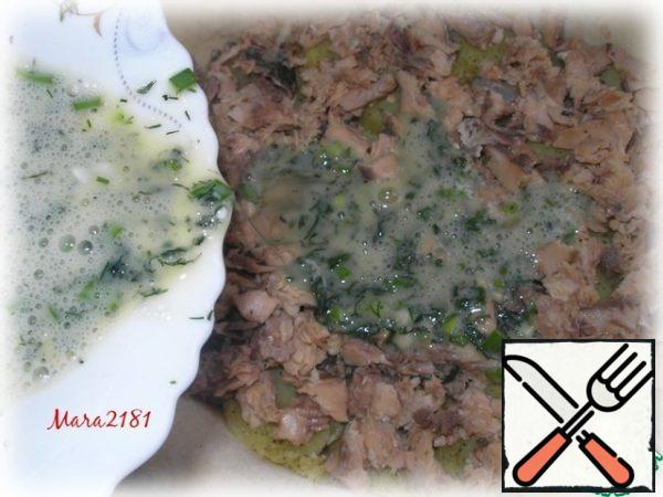 Next, lay out a layer of canned pink salmon (pre-drain the liquid and remove the bones).
In a separate container, whisk 3 eggs, add salt, finely chopped dill and green onions (to taste), mix thoroughly. Pour the egg mixture evenly over the canned pink salmon.
