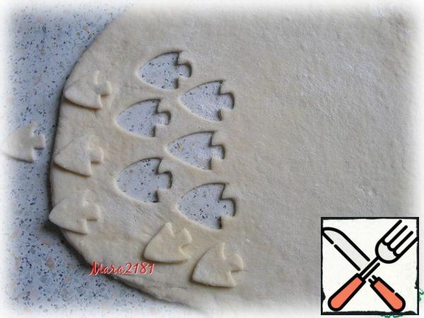 From the rest of the dough, I roll out a layer of the required size with a thickness of 5-7 mm. In the middle, using a mold, I cut out a pattern in the form of a fish.
By the way, the fish itself can also be baked and used as a decoration when serving.
