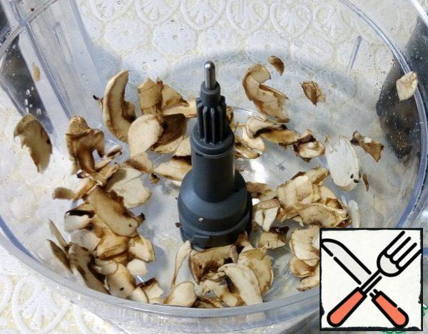 Chop the mushrooms with a shredding attachment, as well as onions, fry in a frying pan, season with salt and pepper.