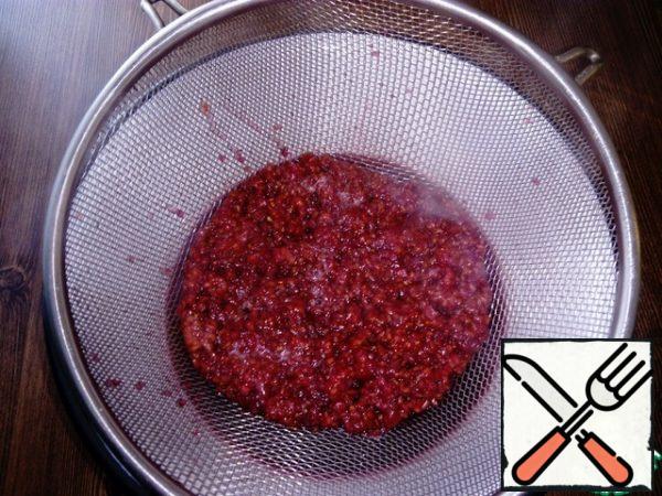- Strain the cooked raspberries through a sieve.